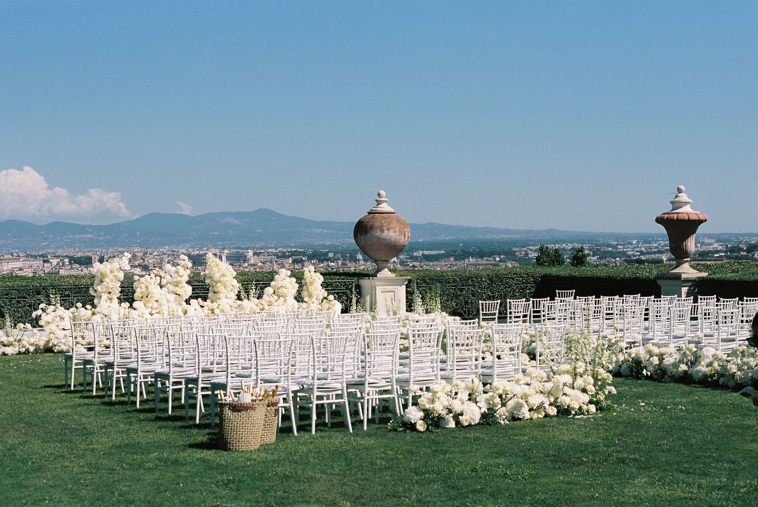 Wedding ceremony in Rome, Italy. Villa Miani. Outdoor ceremony with white florals and seating.