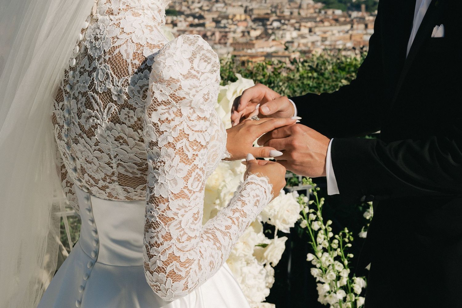 Close up shot of bride and groom during ceremony putting on rings