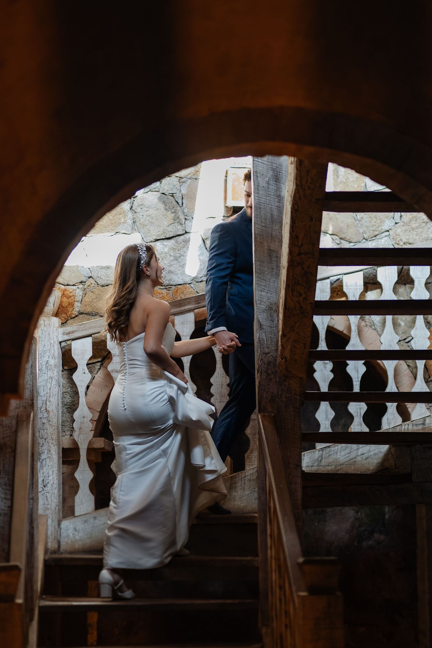 Two people sitting together in a romantic moment on vintage stone balcony steps with ornate balusters.
