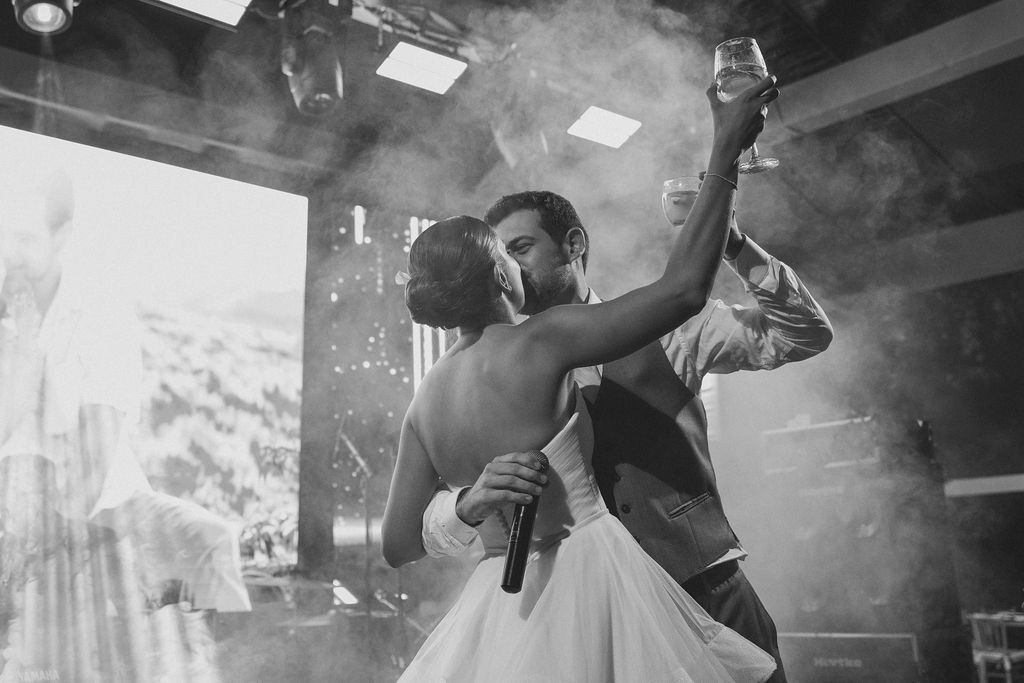A romantic first dance at a wedding reception with smoke and dramatic lighting creating a magical atmosphere.