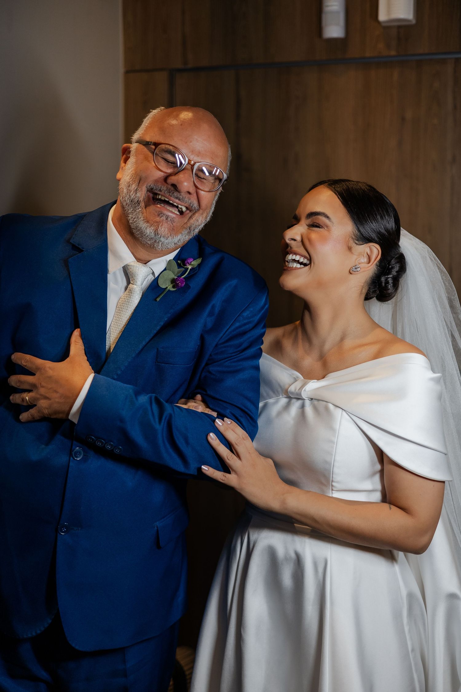 An emotional father-daughter dance moment captured at a wedding reception shows laughter and joy.