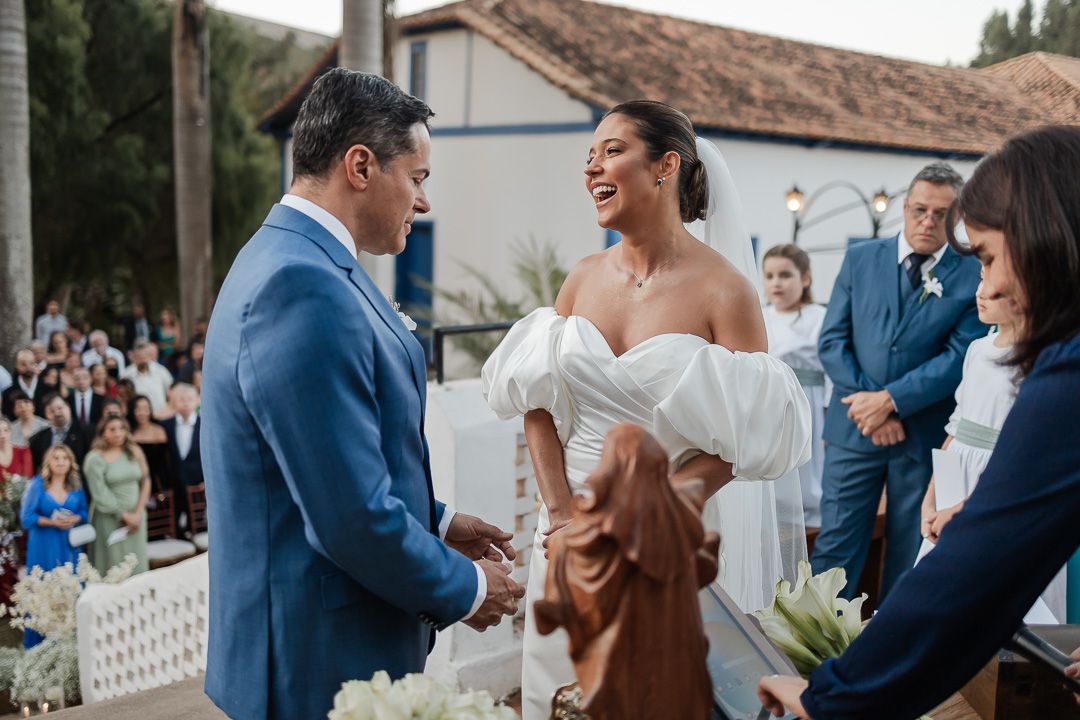 A joyful wedding ceremony takes place outdoors at a venue with Spanish-style architecture.