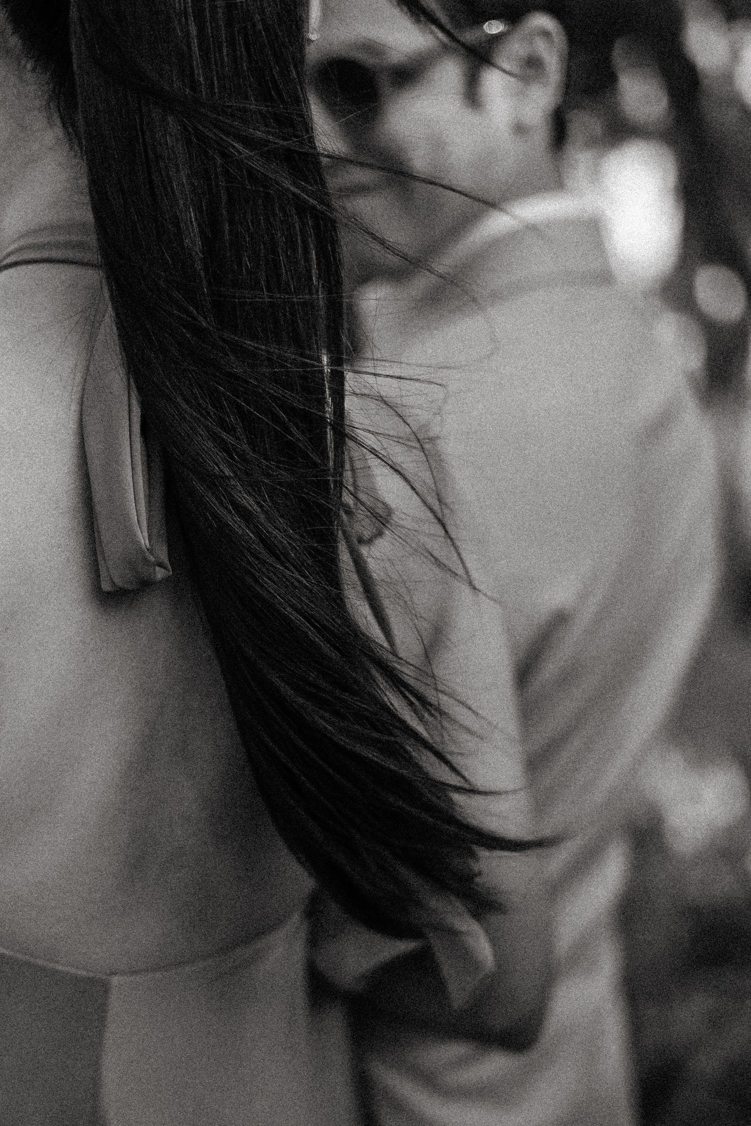 Black and white artistic portrait series showing close-up details of dark hair against a blurred background.