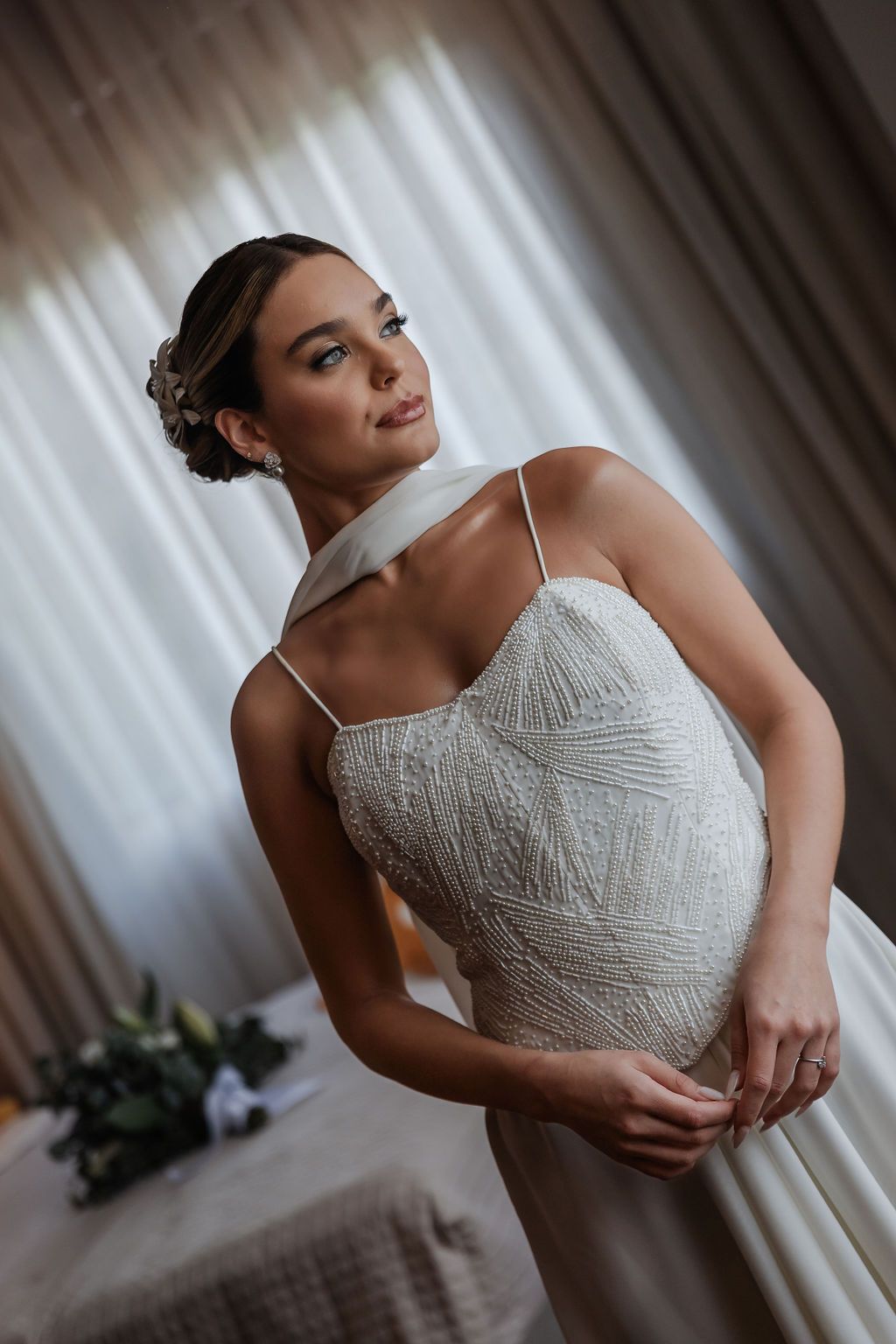 Beautiful wedding dress with intricate lace detailing and spaghetti straps photographed in soft natural light.