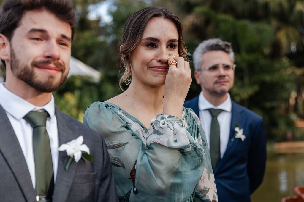 Wedding ceremony emotional moment with guests watching outdoors on a sunny day.