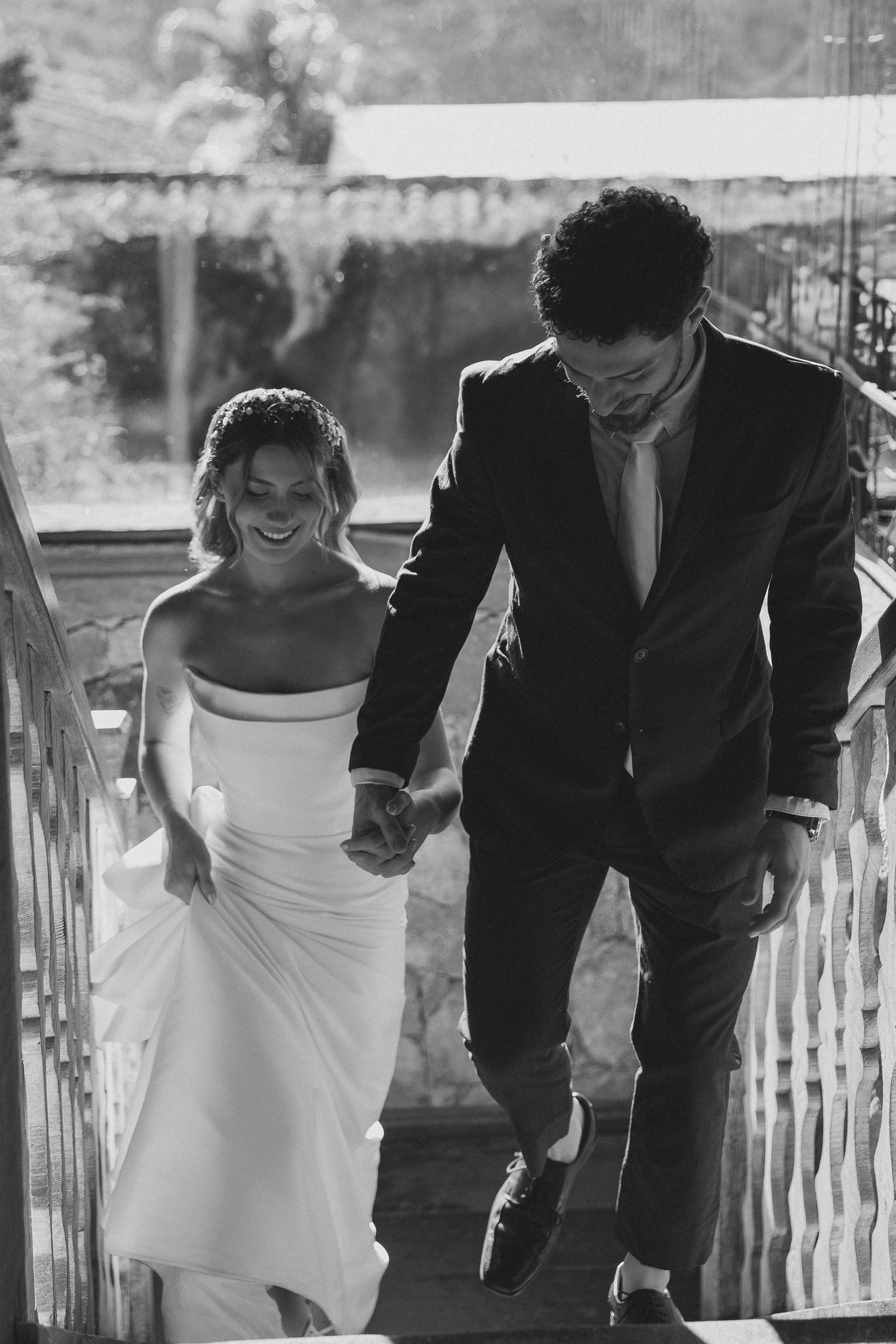 Black and white romantic photo sequence shows couple laughing and running together on a wooden porch.