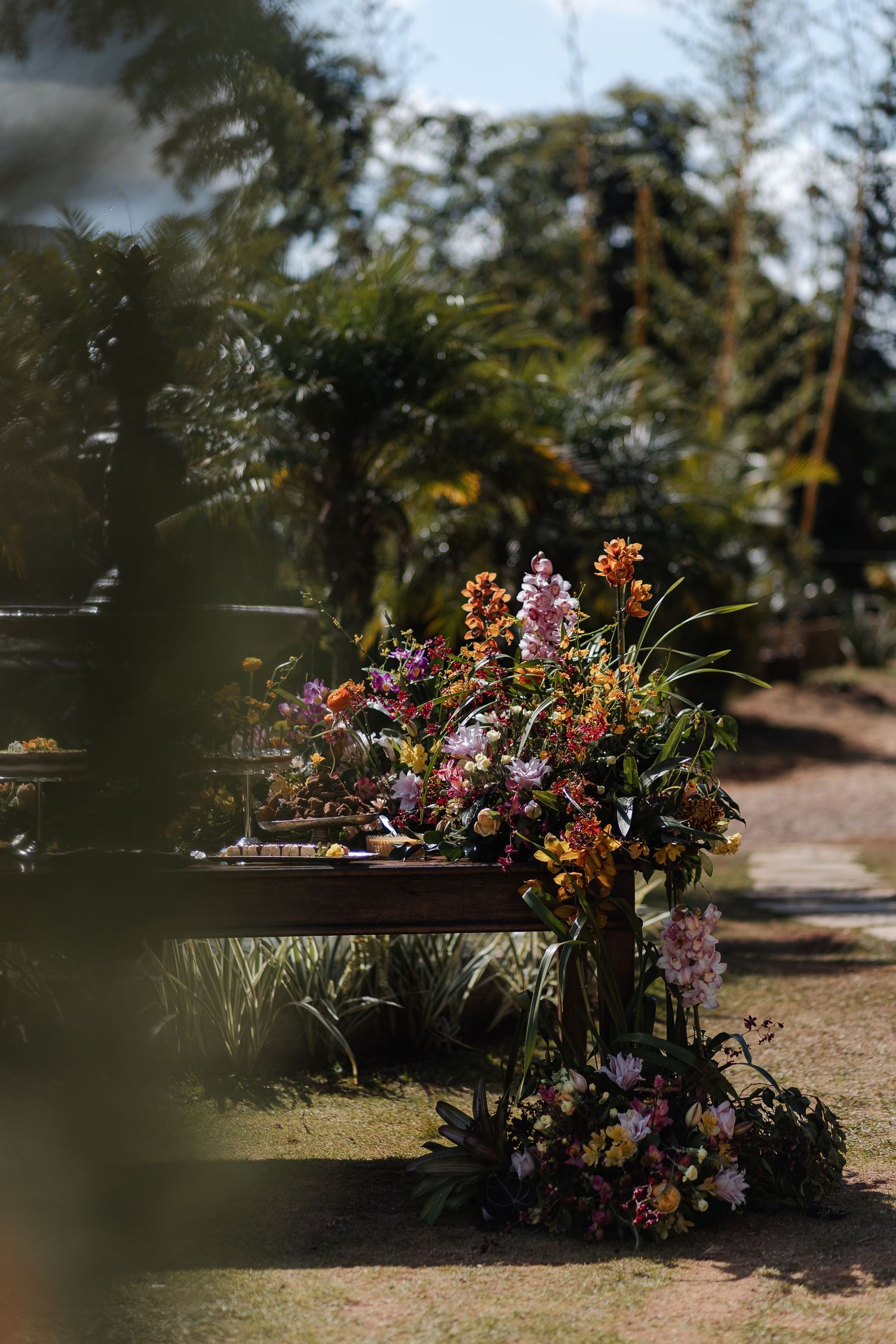 A rustic wooden bench adorned with colorful wildflowers and greenery in a natural outdoor garden setting.