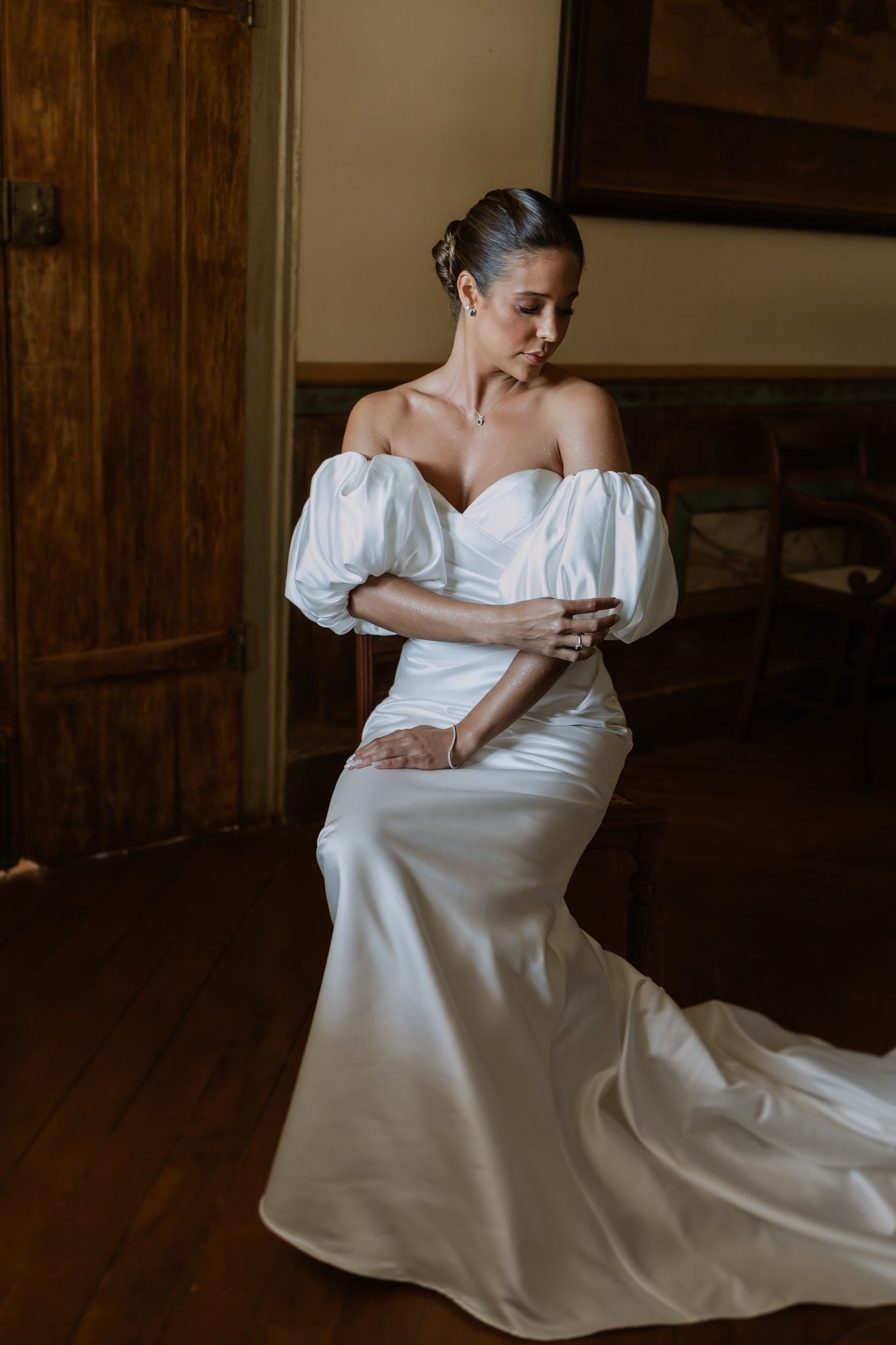 Foto espontânea dos noivos nElegant bride wearing a modern white off-shoulder wedding gown with dramatic puff sleeves and fitted silhouette.
