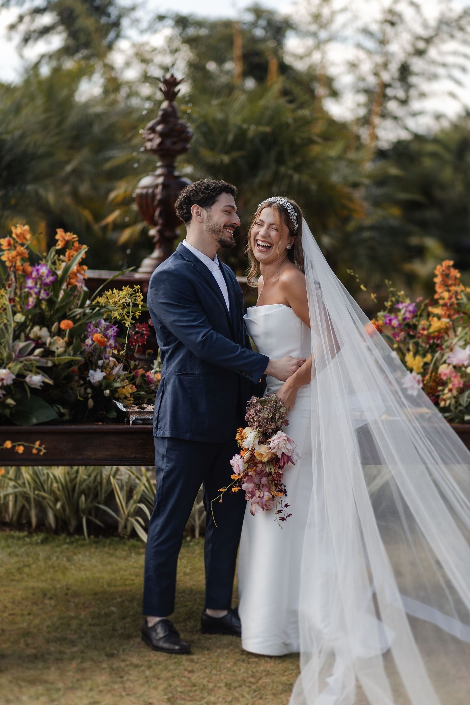 A joyful outdoor garden wedding celebration with the couple sharing an intimate moment among vibrant autumn flowers.