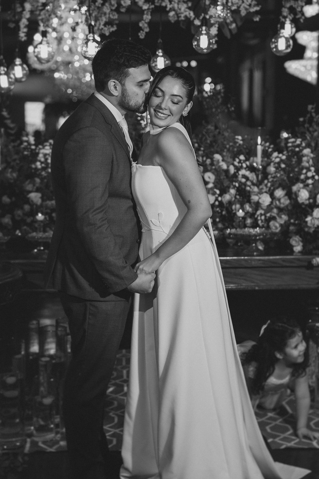 A romantic black and white wedding photo showing a couple embracing during their special celebration.
