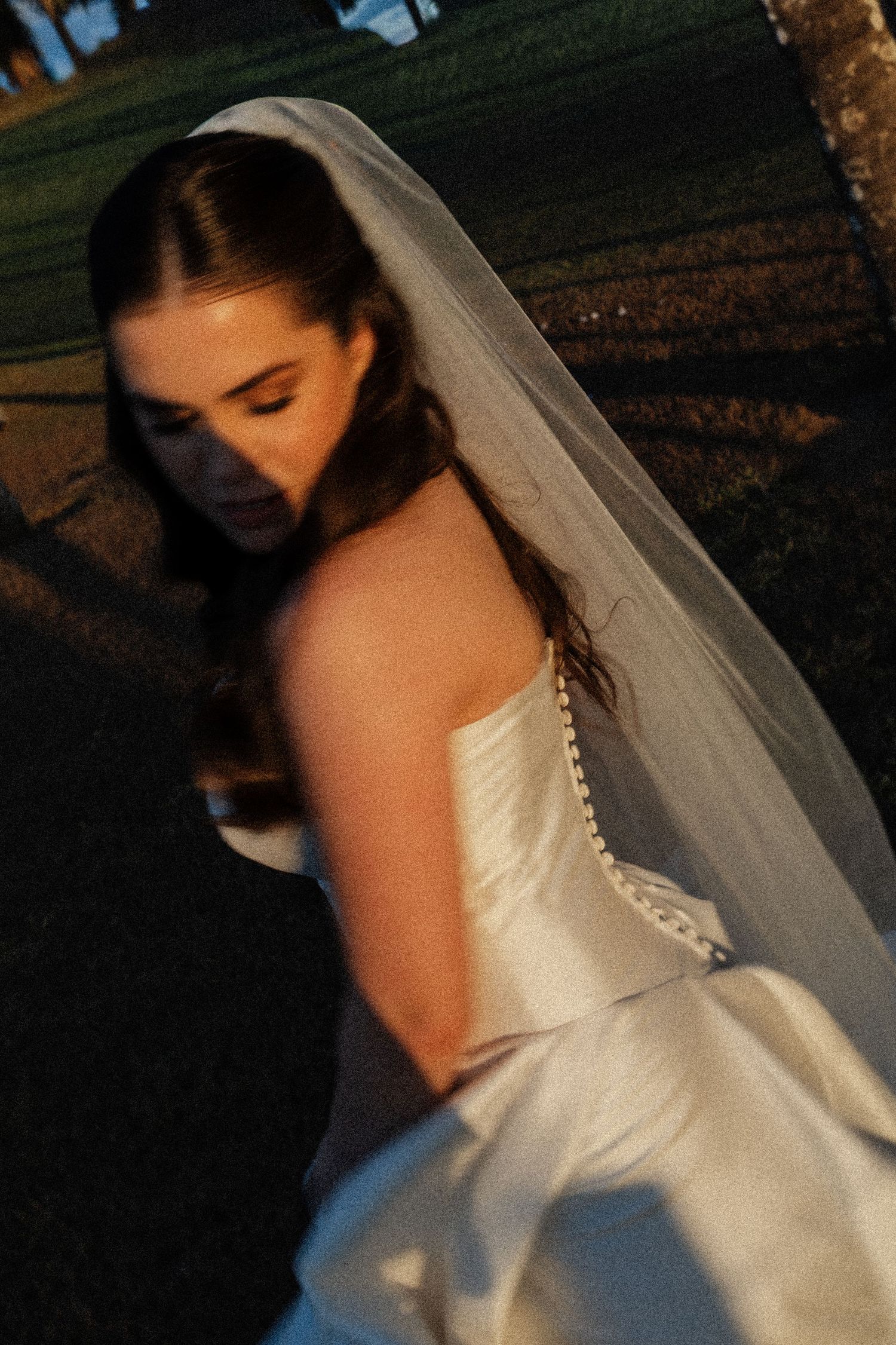 A bride in a white wedding dress and flowing veil is captured in a series of artistic profile shots at dusk.