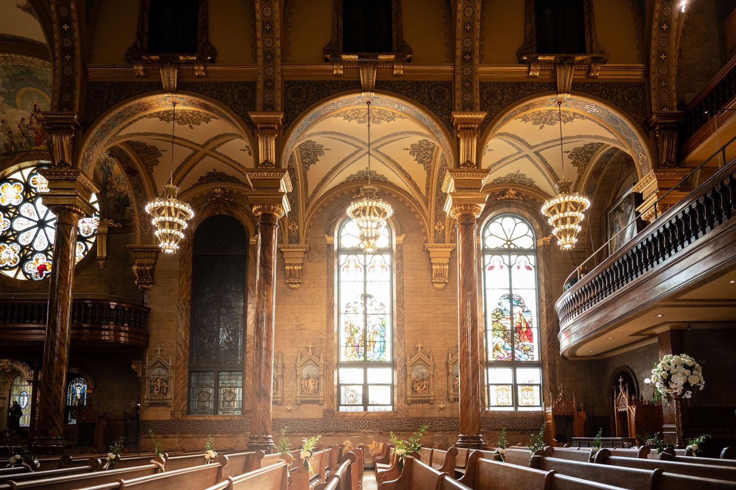 Panoramic view of an ornate historic ballroom interior with grand chandeliers, arched windows and gilded architectural details.