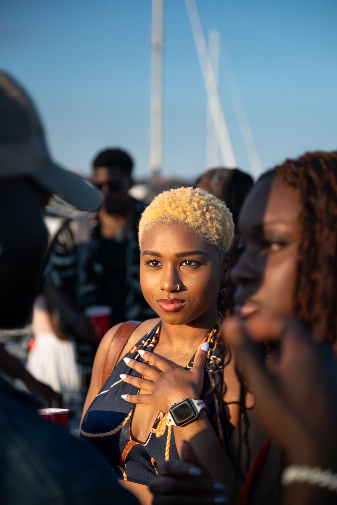 Person with blonde hair and jewelry captured in golden sunset lighting.