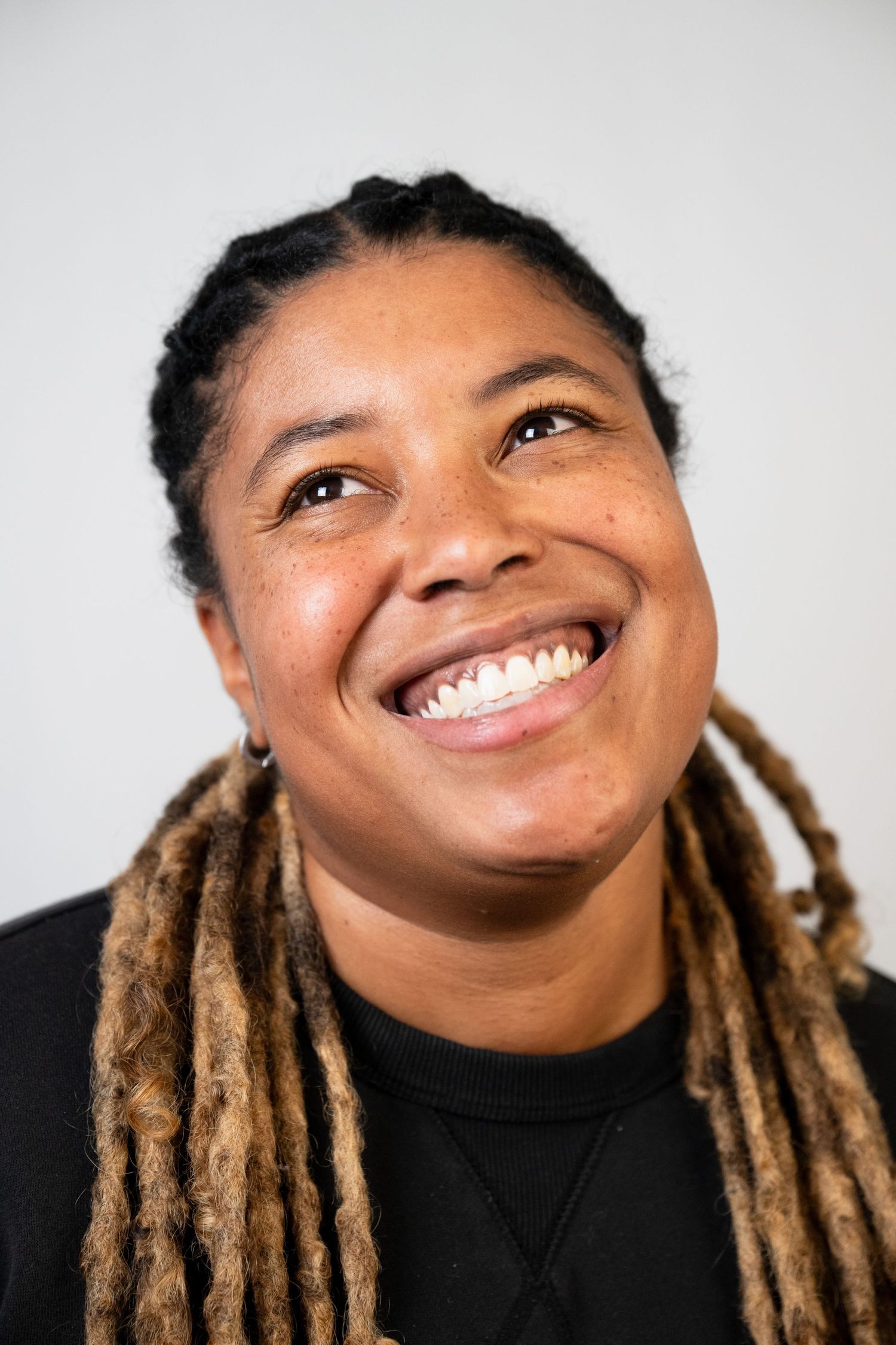 Close-up portrait series showing bright smiles and blonde locs hairstyle.