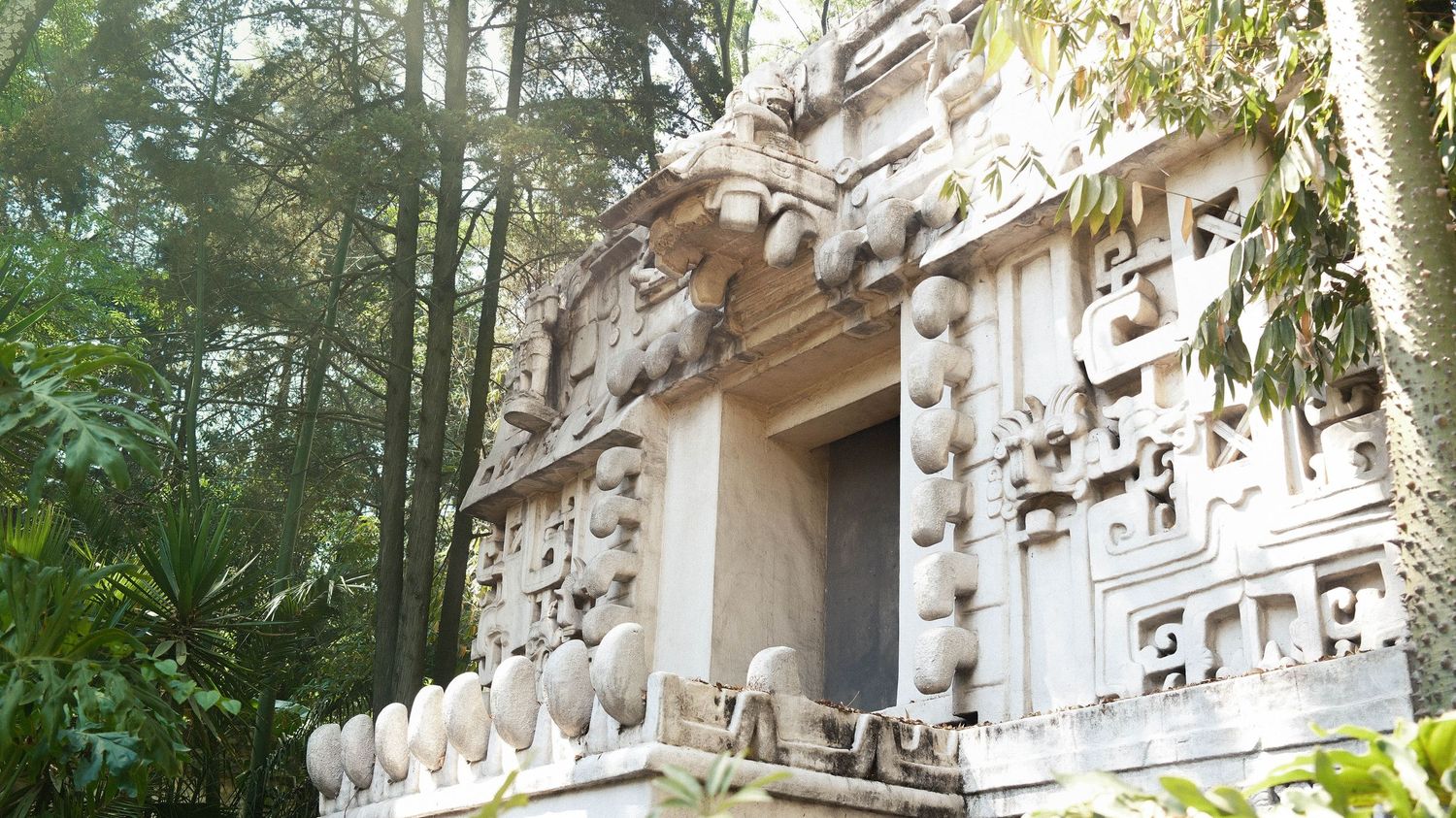 Ancient carved stone temple walls and ornate architectural details in Angkor Wat, Cambodia show intricate religious artwork.