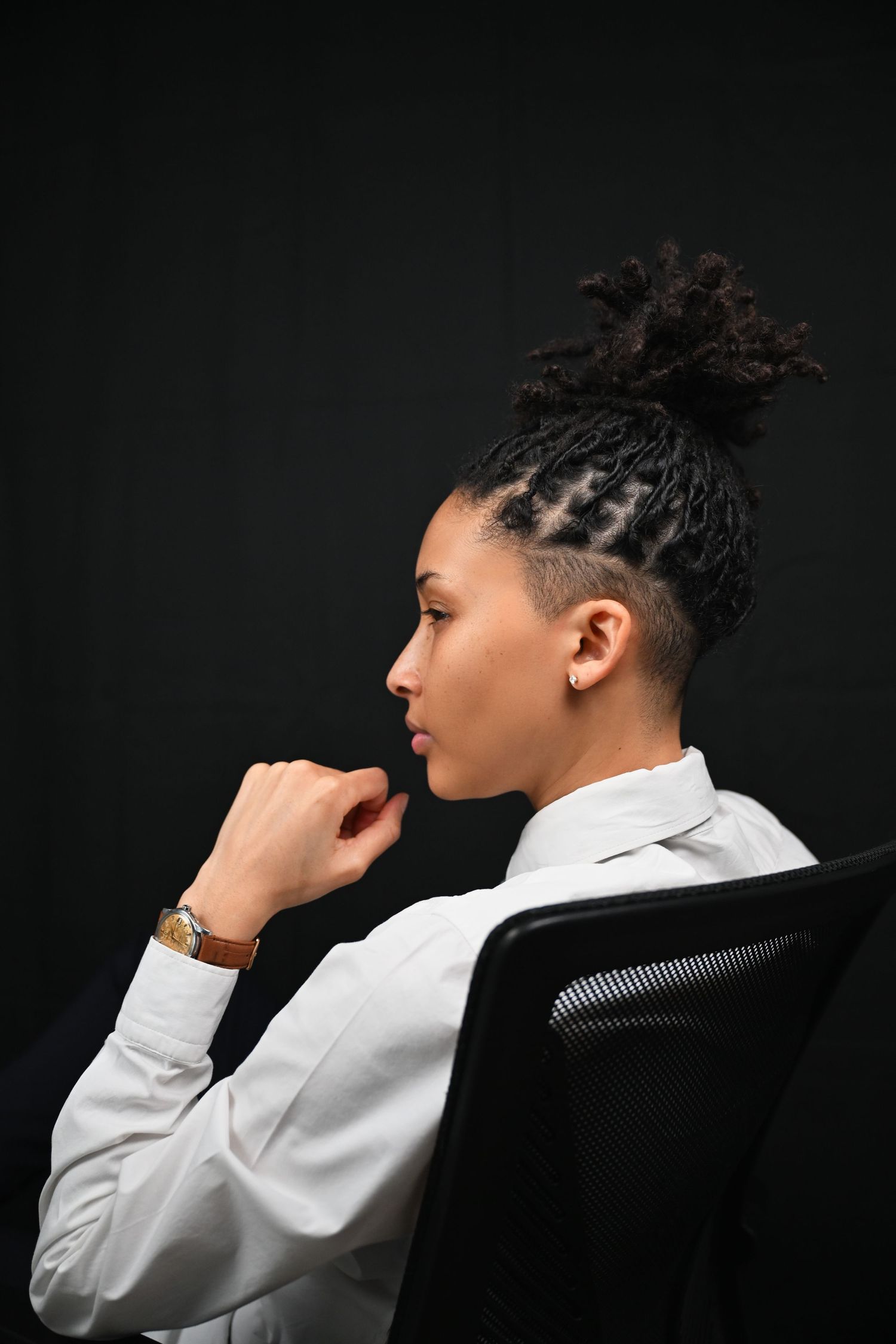 Dramatic side profile portraits against dark background showing person in white attire.