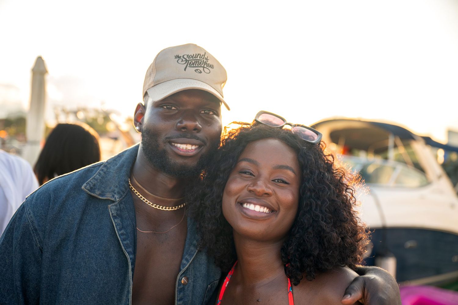 Couple enjoying outdoor event together at sunset with genuine smiles.