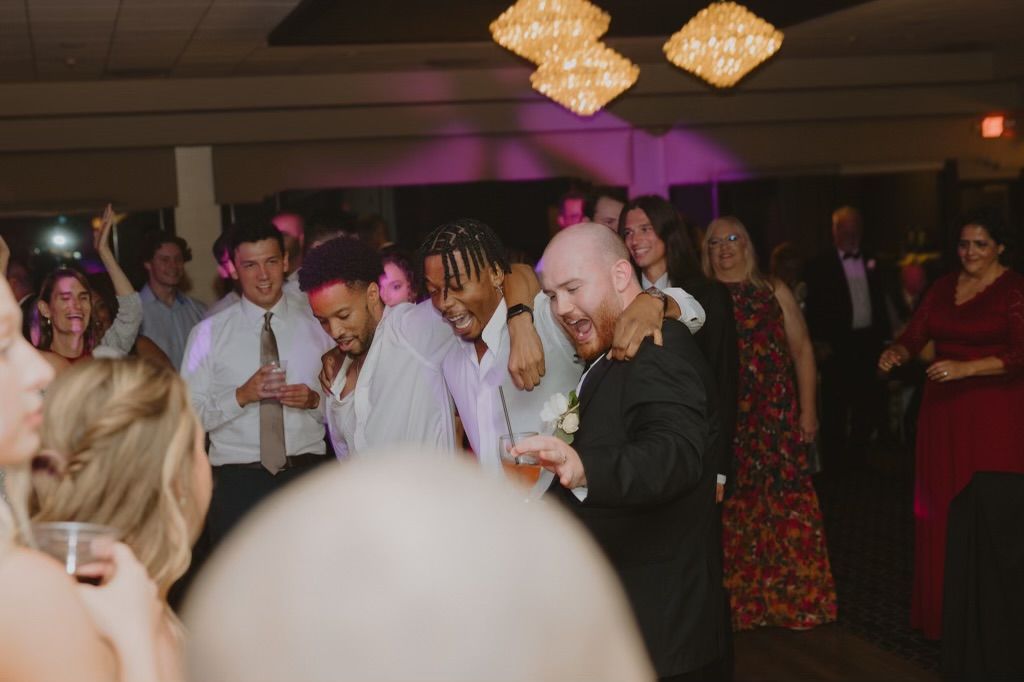 Wedding reception dance party with elegant lighting and decorative chandeliers.