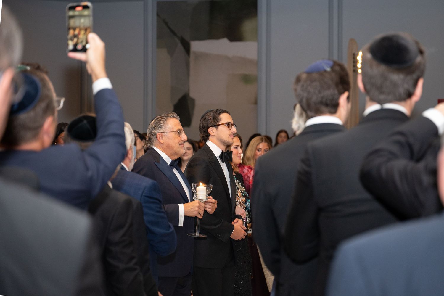 A crowd of people in formal business attire gather at a professional networking event.