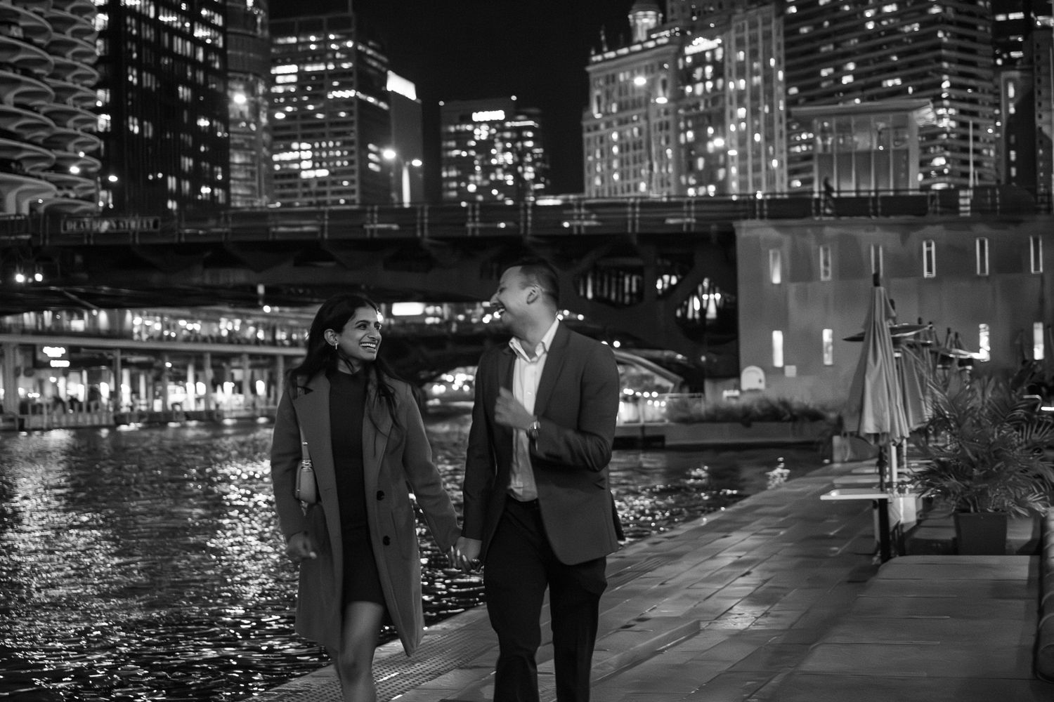 Couple sharing conversation while walking along Chicago's riverside at night.