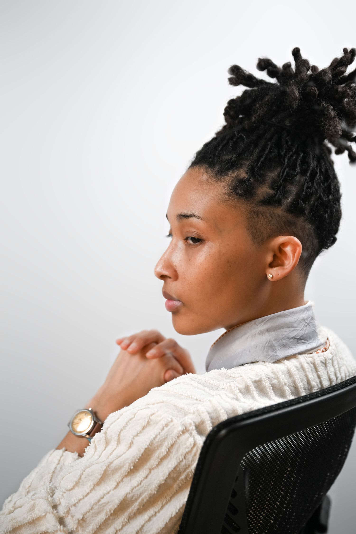 Series of profile shots showing person in white sweater seated in office chair.