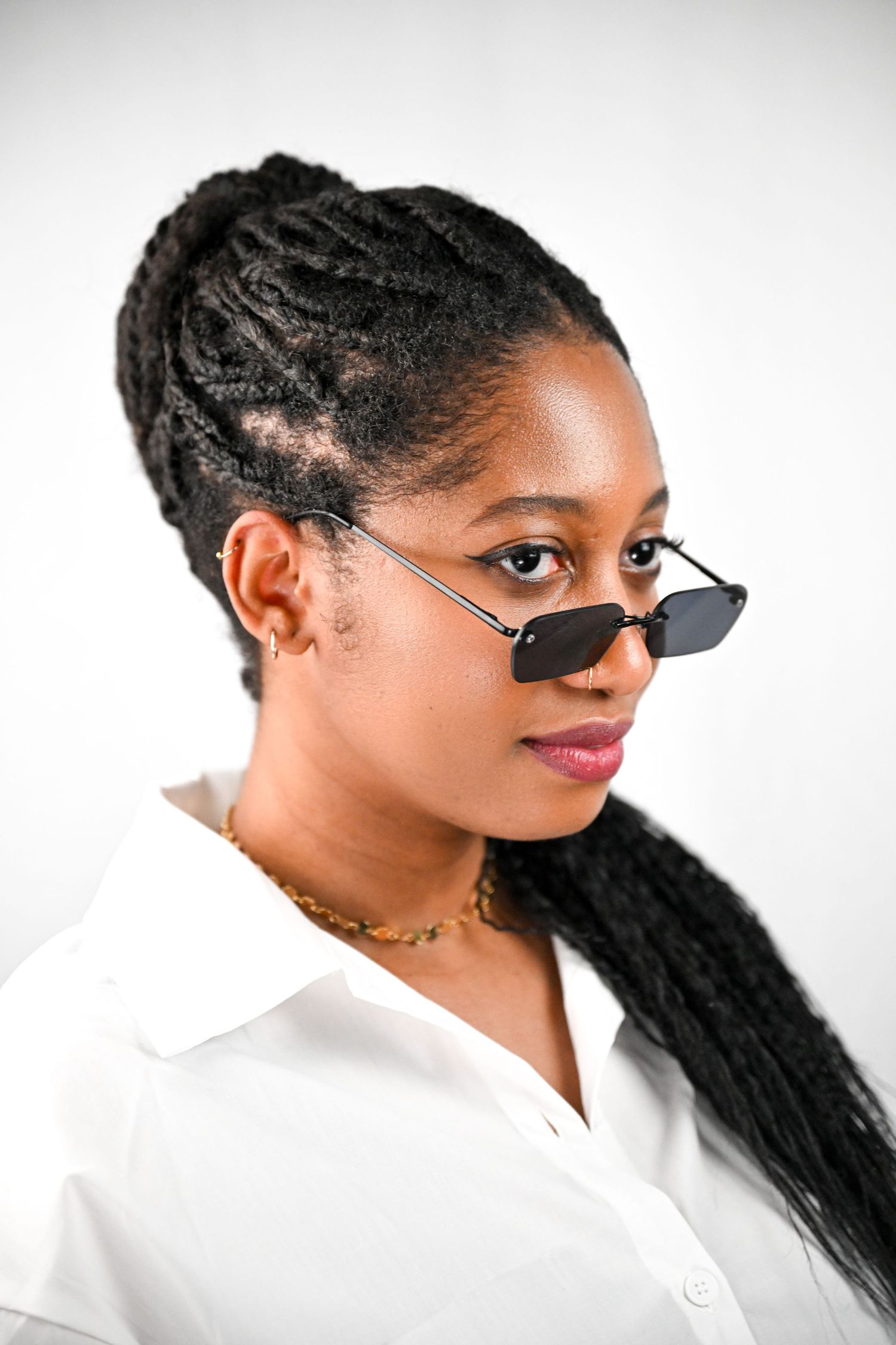 Fashion portrait with small rectangular sunglasses and elegant white collar shirt.
