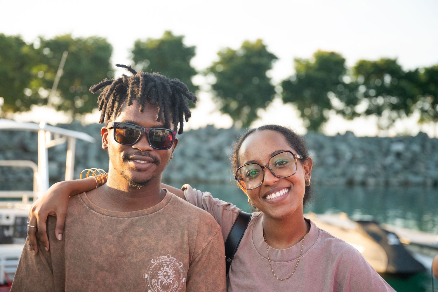 People enjoying a sunny outdoor gathering with sunglasses and smiles.