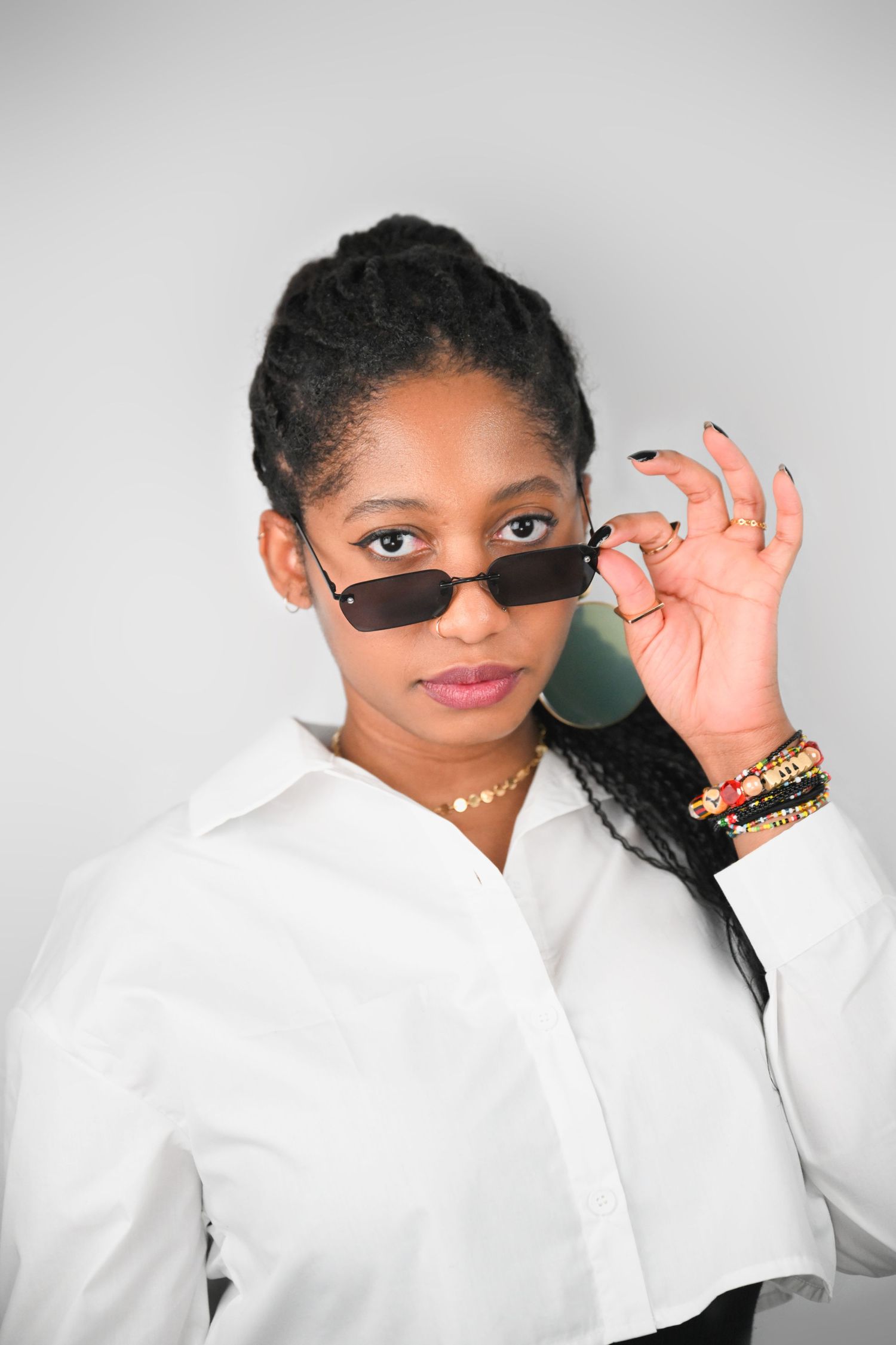 Modern fashion portrait with sleek sunglasses and crisp white button-down shirt.