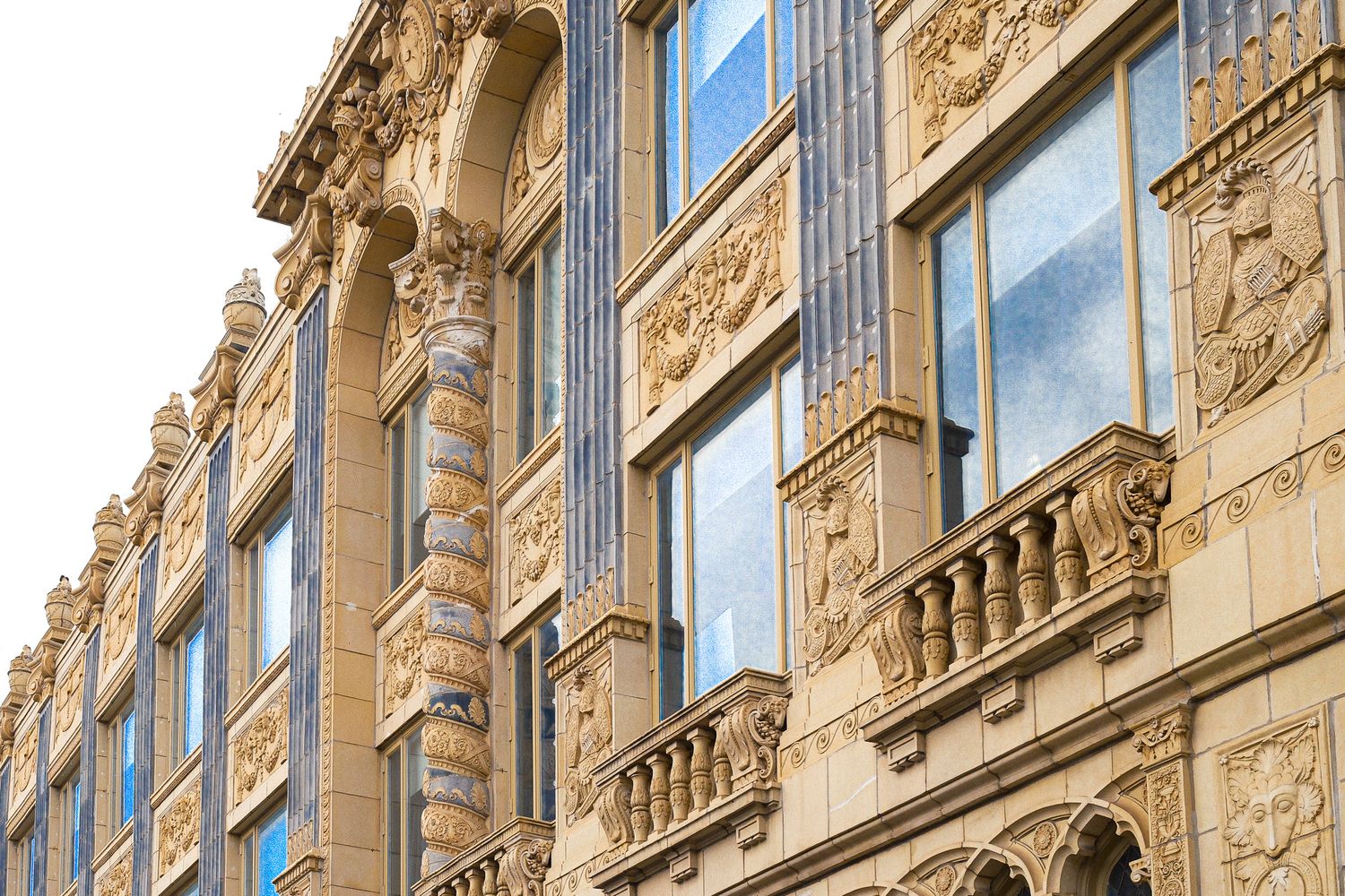 Ornate architectural details and windows on a historic building facade with decorative stonework.