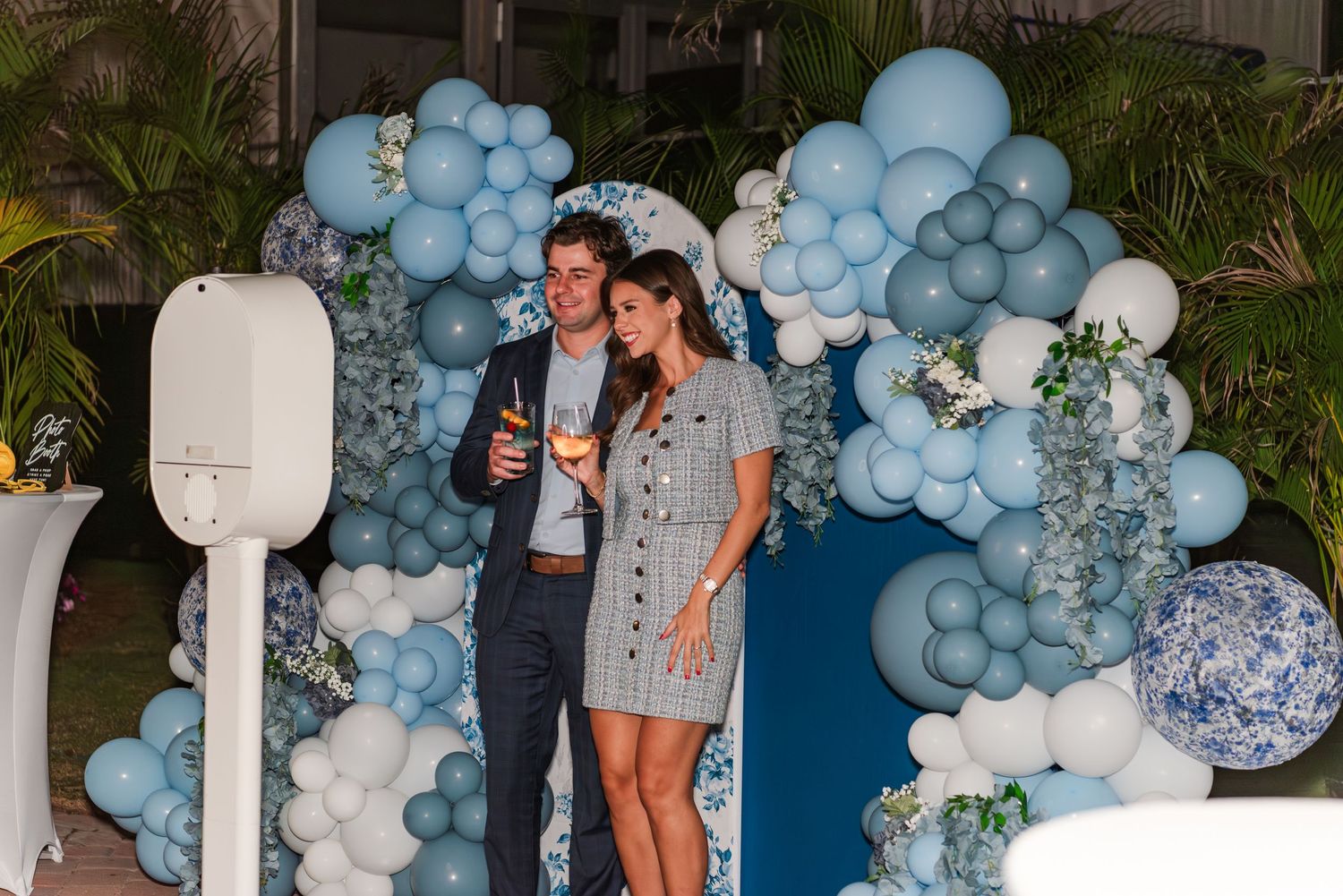 Decorative balloon arch installation featuring blue and white balloons with elegant floral accents.
