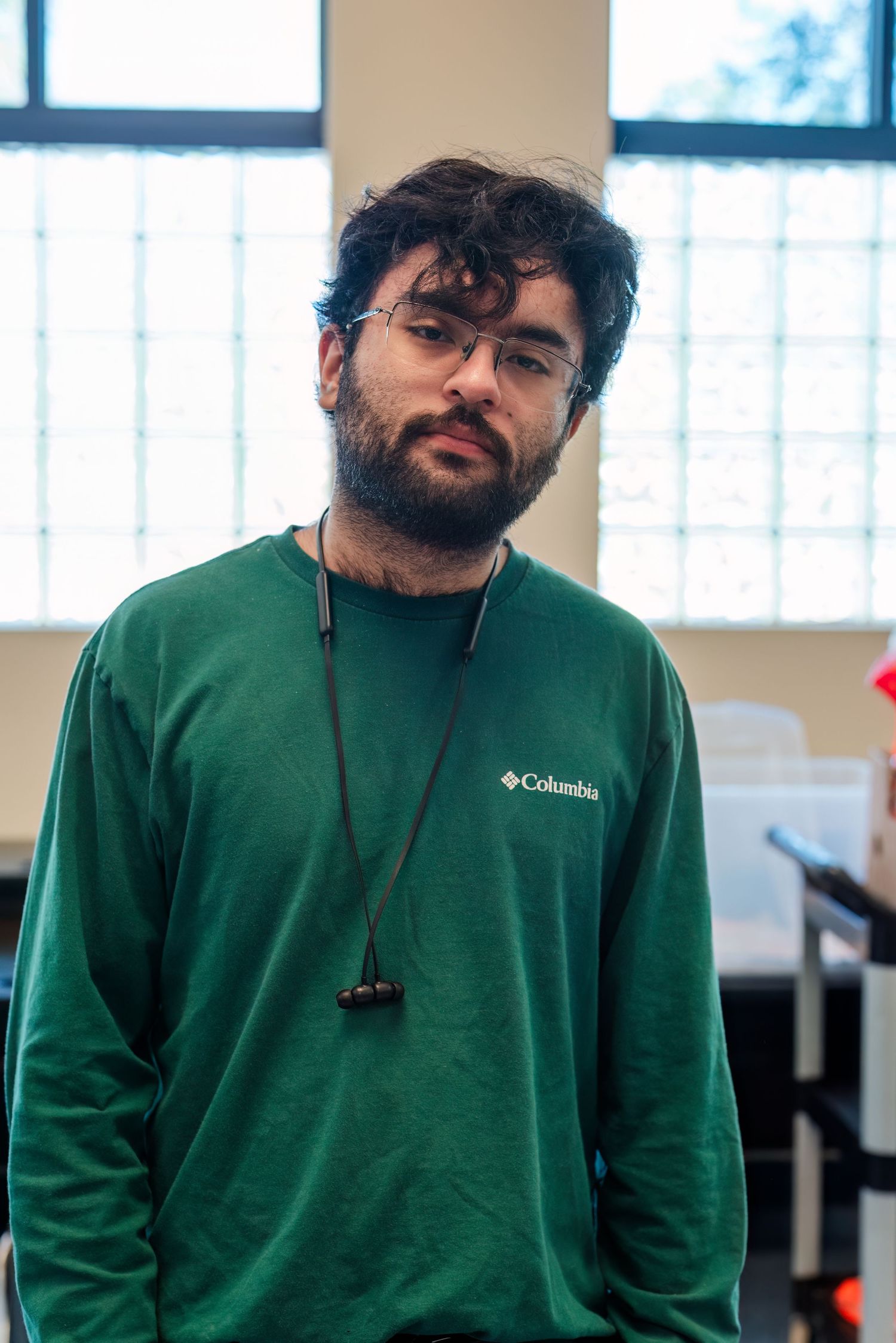 Person in green Columbia sweatshirt shown from different angles in office setting.