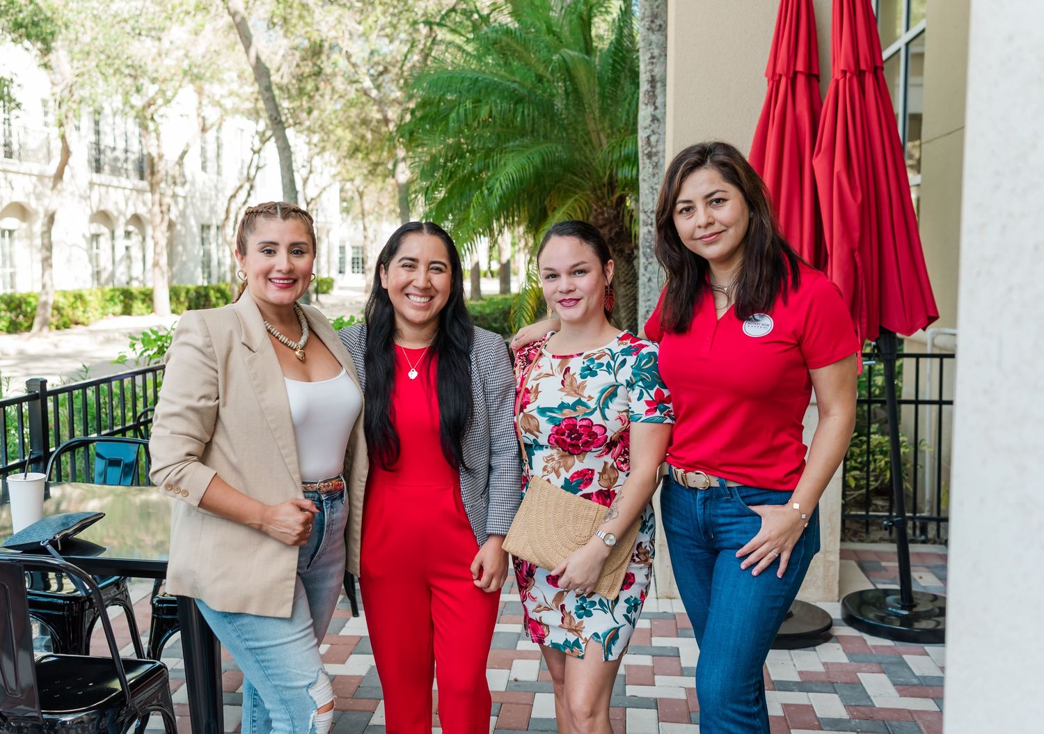 A group of people wearing coordinated red outfits gather together outdoors for a casual photo.