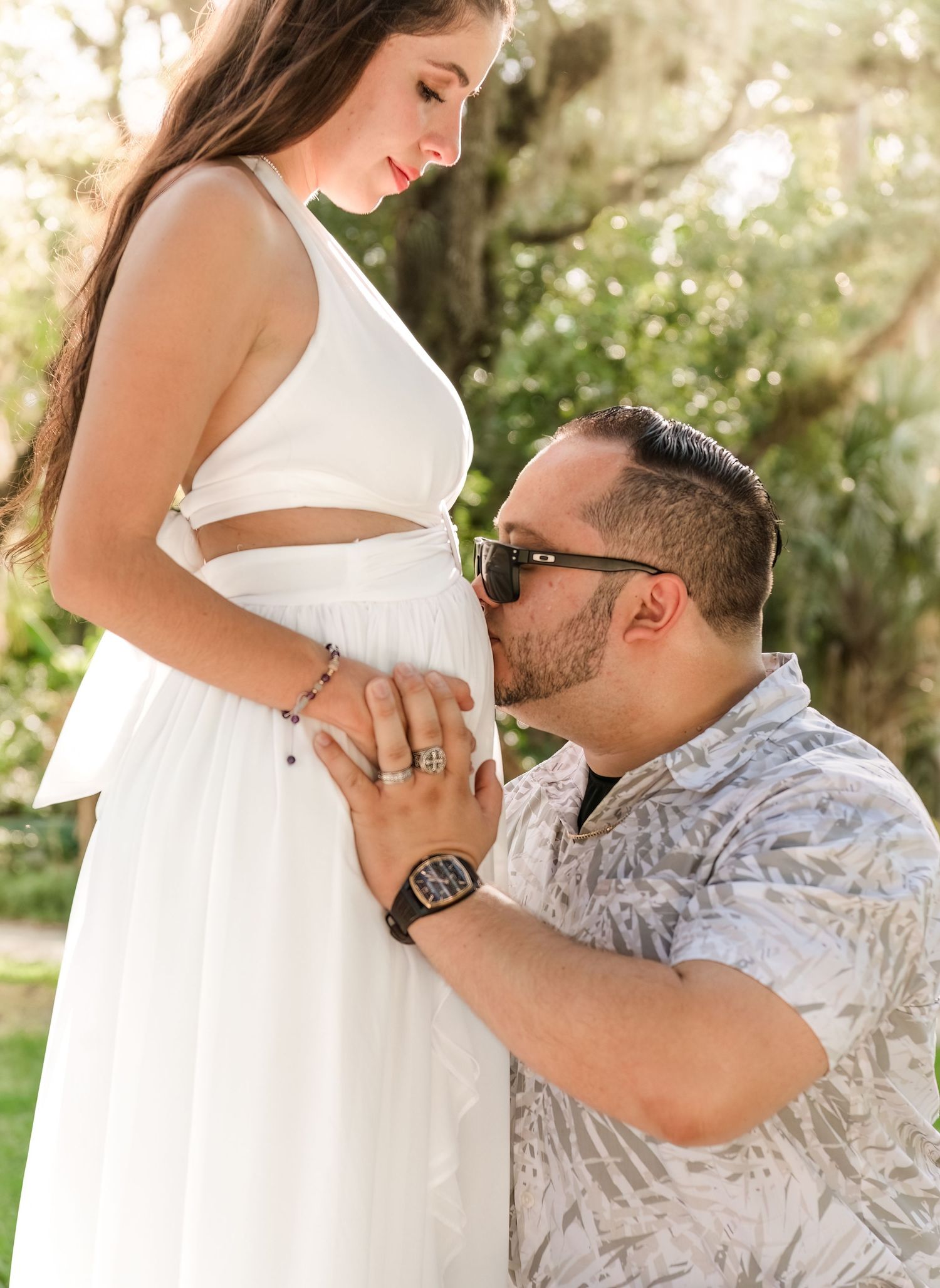 A touching maternity photoshoot series showing tender moments between expecting parents in a natural outdoor setting.