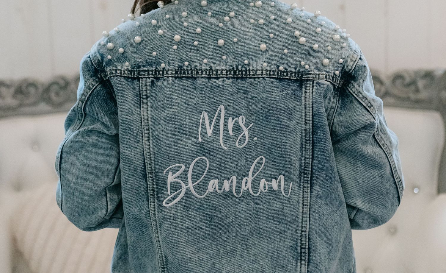 Pearl-embellished denim jacket with Mrs. Blandon custom bridal text on back.