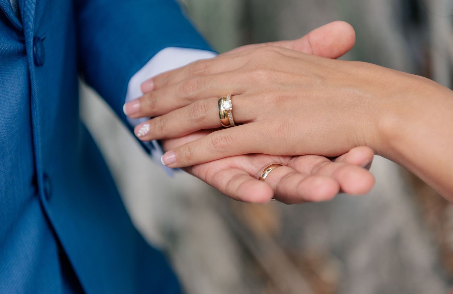 Close-up view of hands displaying a wedding band ring in a tender moment.