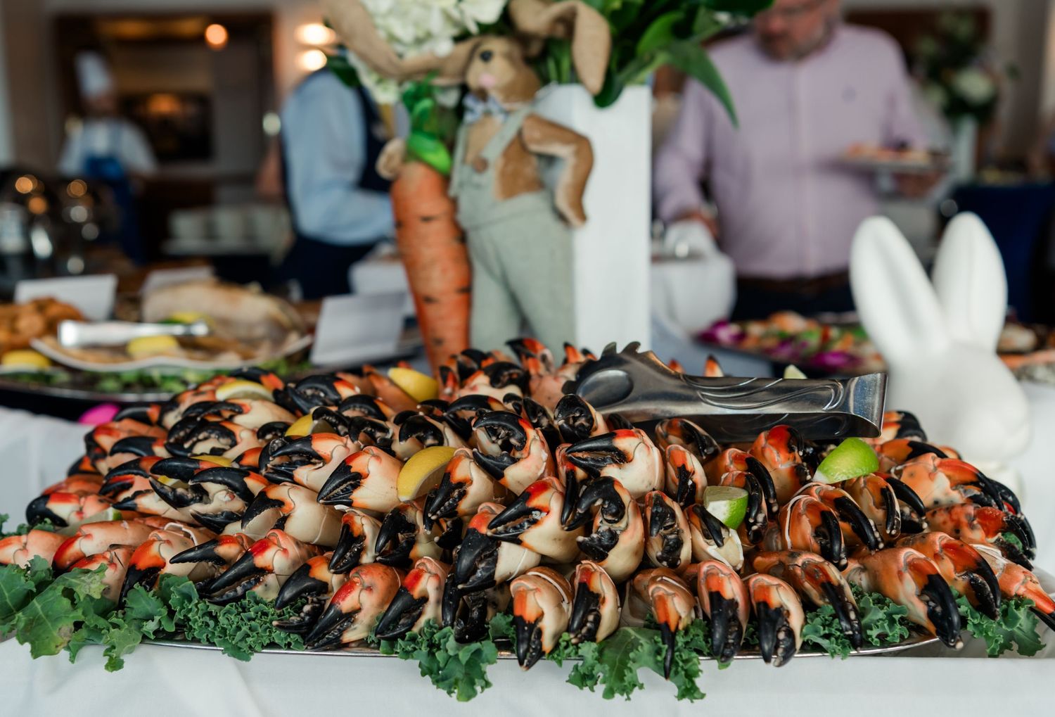 Elegant seafood buffet display featuring shrimp and mussels on skewers arranged on a large platter with kale garnish.