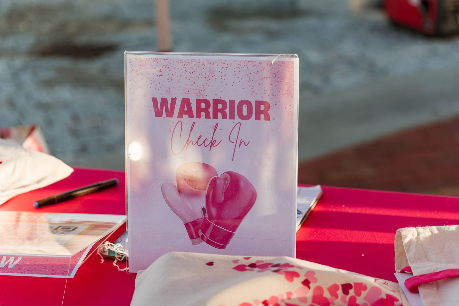 Pink and white cards and decorative items arranged on a table with a soft blue background.