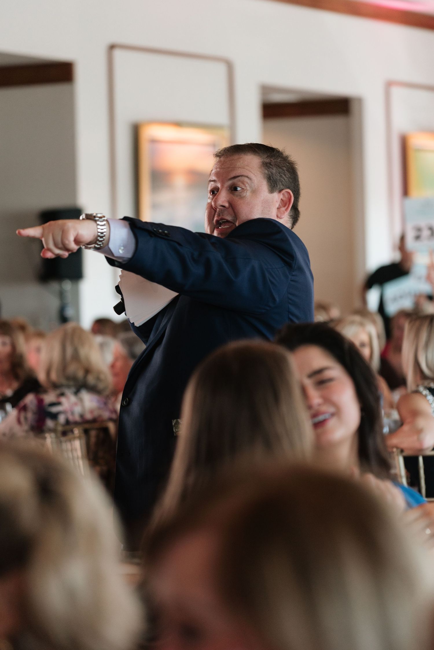 A person in a crowd performs a dab dance move with arms raised in a sequence of photos.