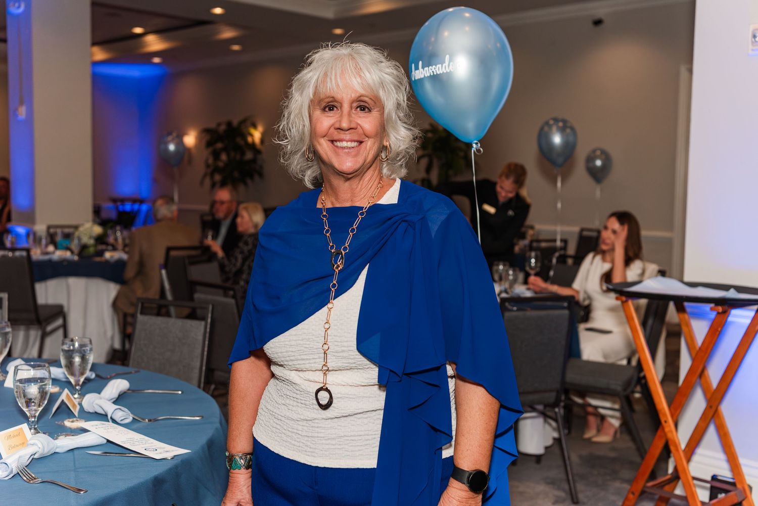 Party event with blue and white balloons and decorations in an indoor venue.