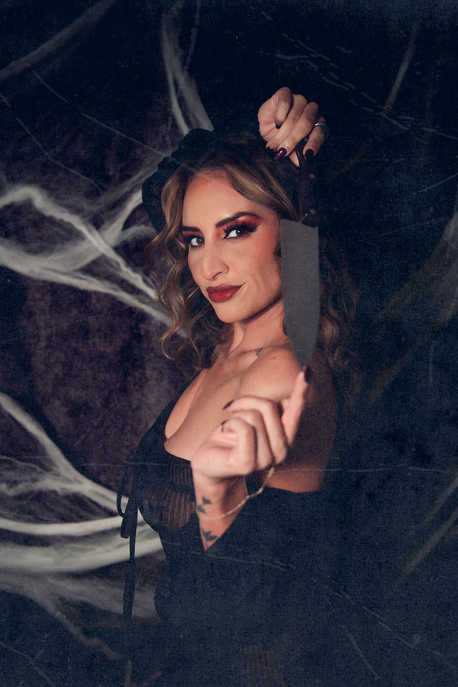 Dramatic portrait series in dark moody lighting with cobweb decorations creating a spooky Halloween atmosphere.