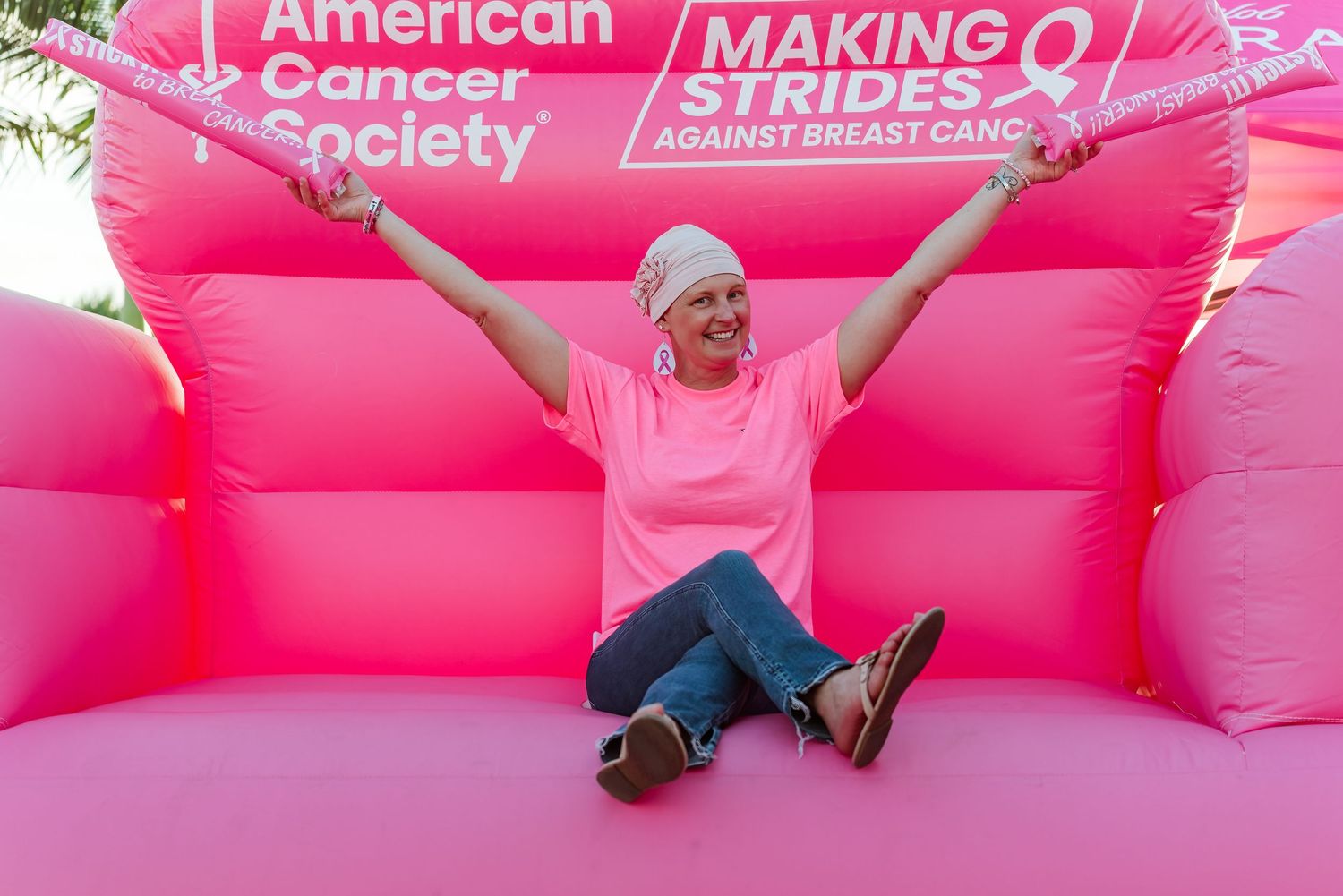 Pink inflatable breast cancer awareness display with American Cancer Society branding.