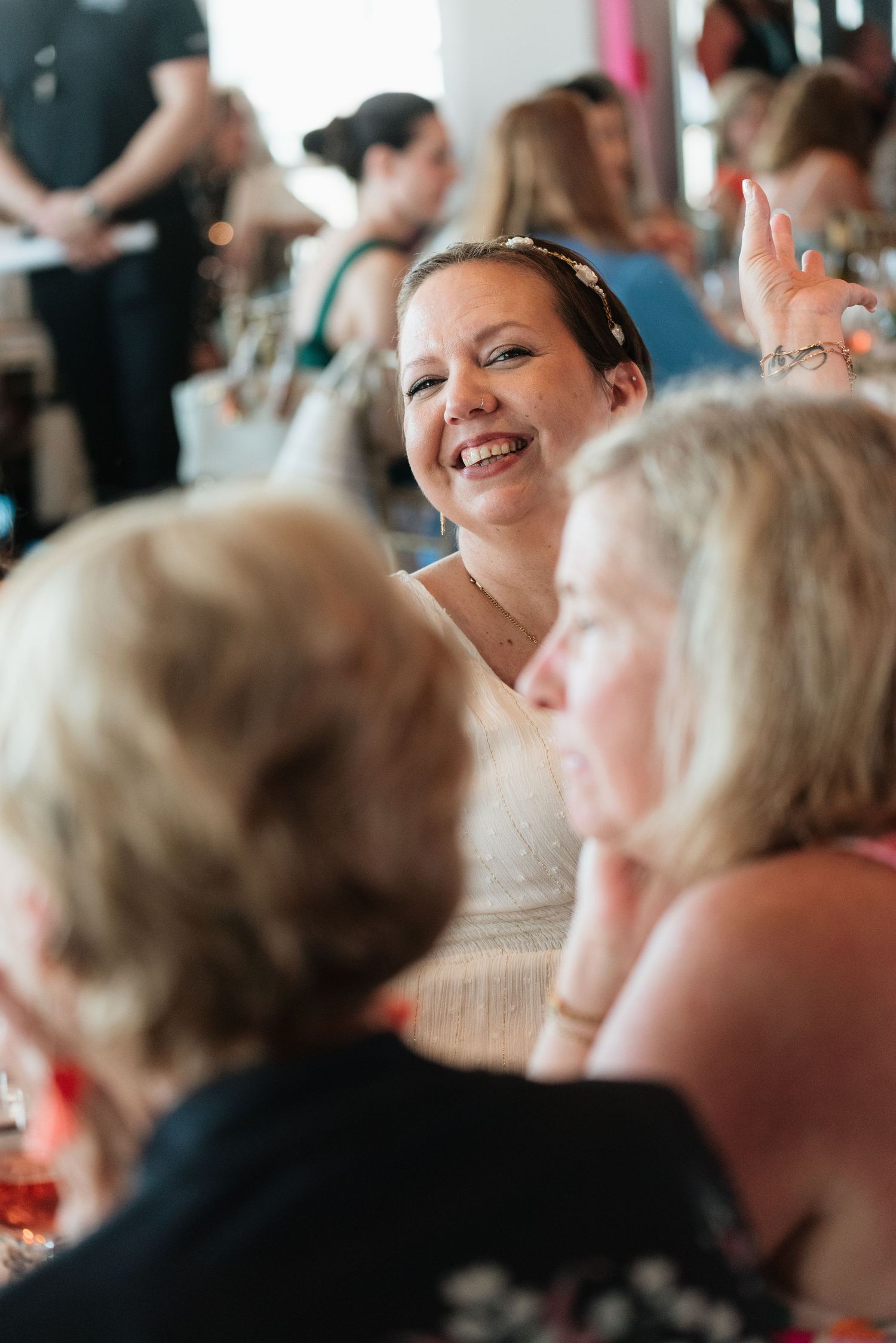 A candid moment captured at a social gathering showing people engaged in lively conversation and laughter.