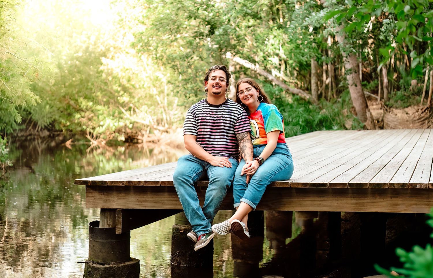 A wooden boardwalk path extends through lush green foliage in a natural outdoor setting during golden hour.