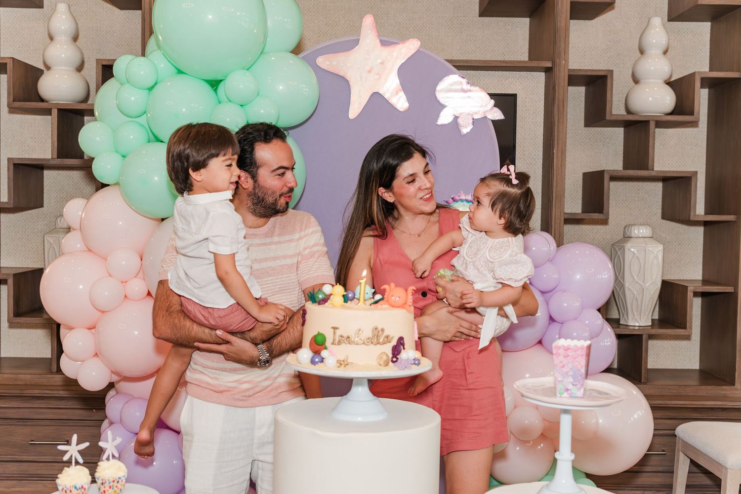 A series of party photos showing a unicorn-themed birthday celebration with pastel balloon decor and a tiered cake.