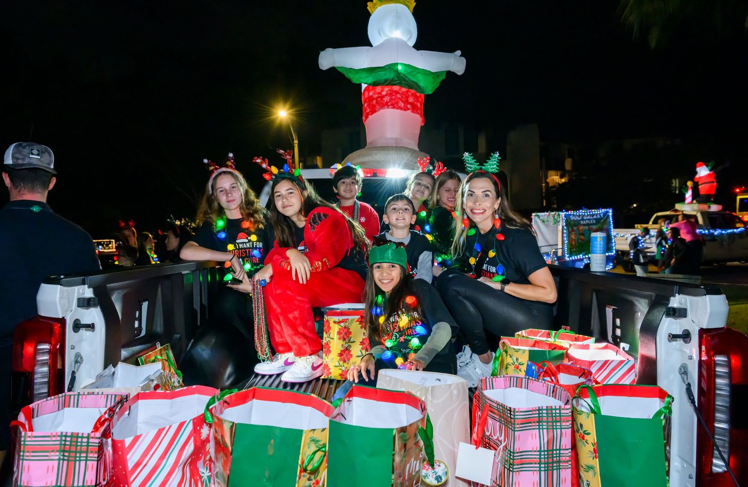 A festive holiday party table decorated with wrapped presents, candy canes, and Christmas ornaments in red and green colors.