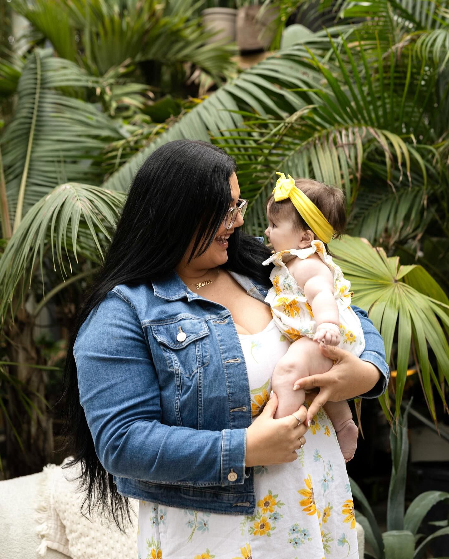 Two people share intimate moments on patio surrounded by tropical greenery.
