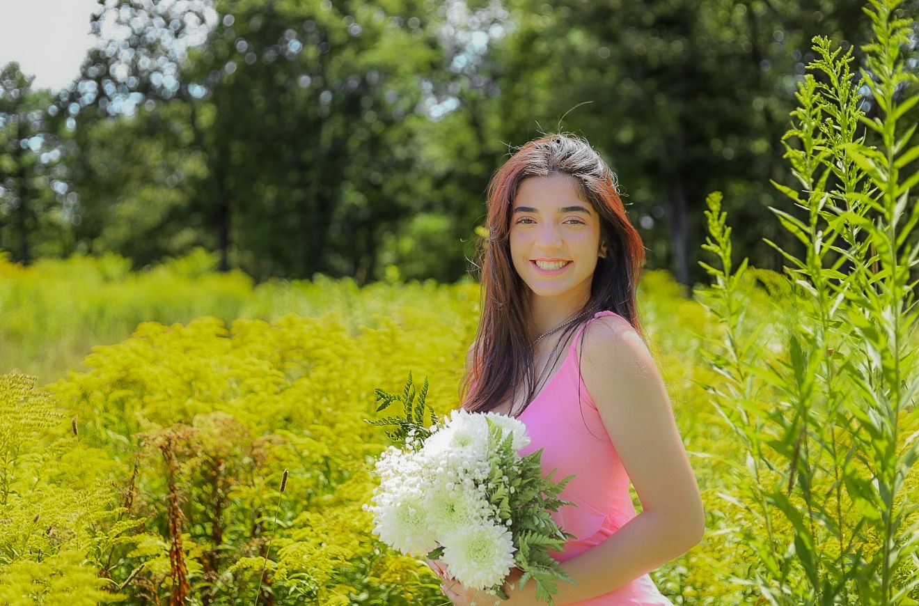 Summer portrait session in a field of yellow wildflowers.