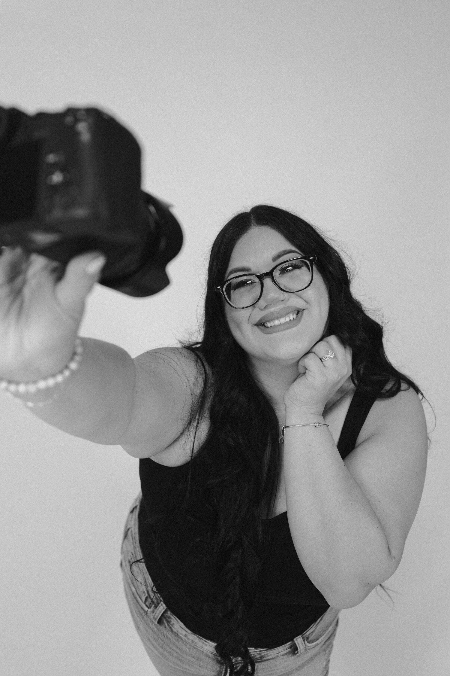 Black and white photo series showing playful poses with glasses and pearls.