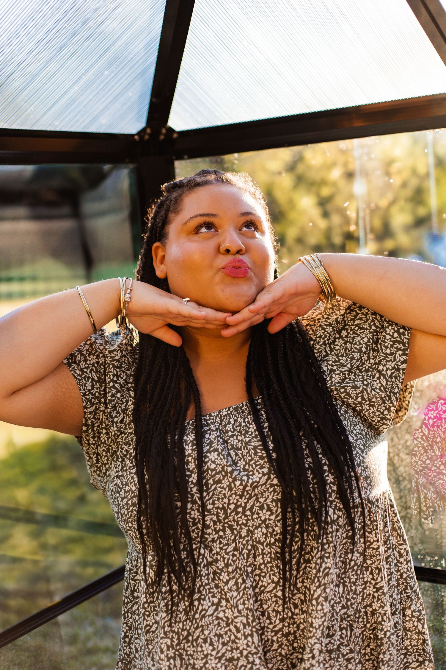 A person in a sparkly dress makes a playful expression while posing under a covered patio.