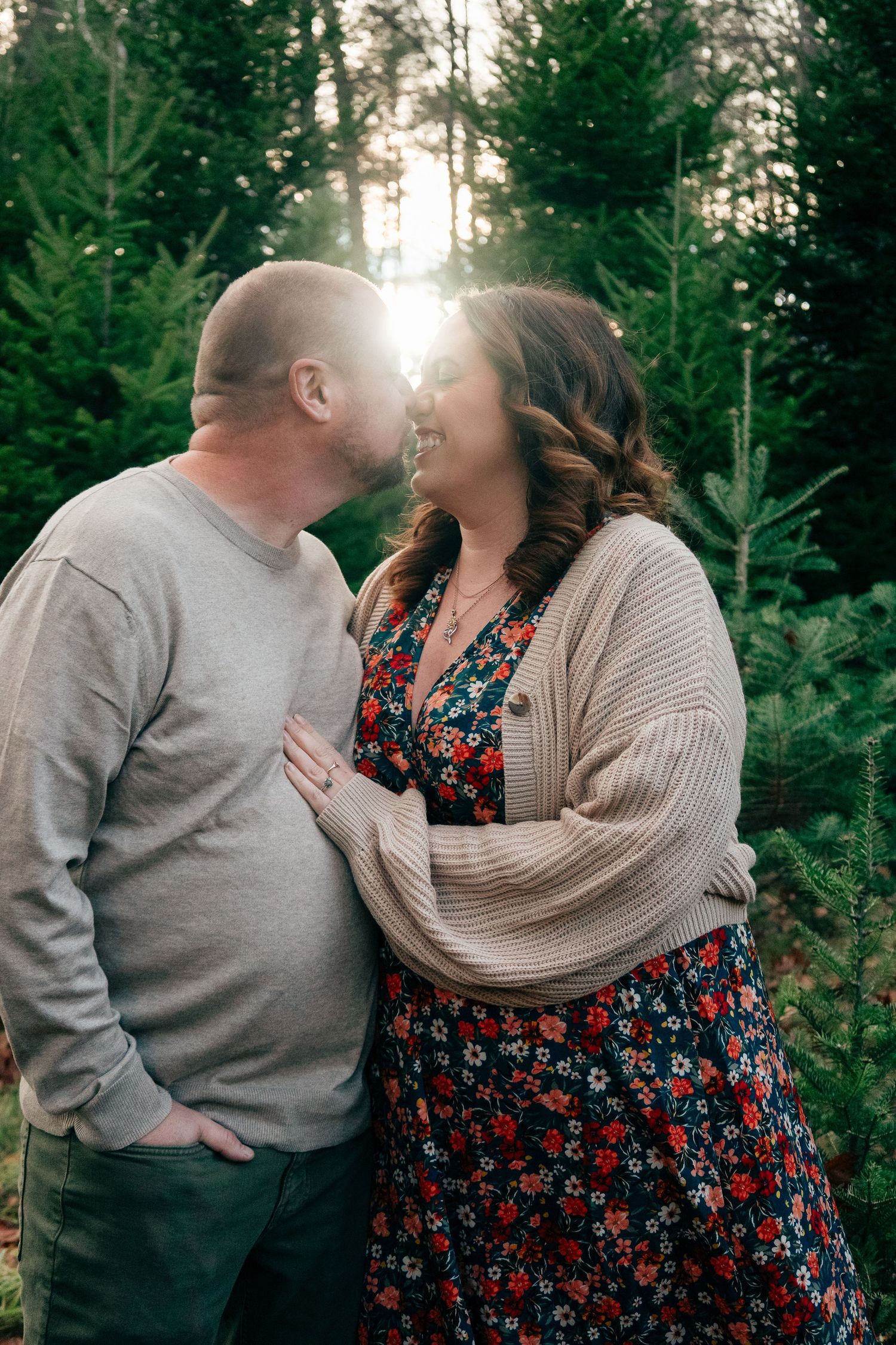 A couple sharing joyful moments together in a forest setting during golden hour.